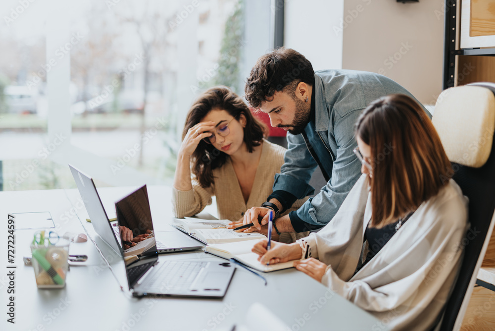 Persistent business team collaborating in a modern office workspace. Happy and successful coworkers working together on project solutions. Persistent business team collaborating in a modern office workspace. Happy and successful coworkers working together on project solutions.