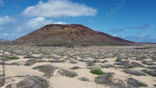 Vista dall'alto drone, splendida veduta aerea di un furgone che viaggia su una strada deserta in mezzo alle montagne a Lanzarote, Canarie.
