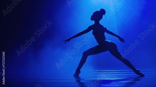 Silhouette of a woman dancer against a background of neon light
