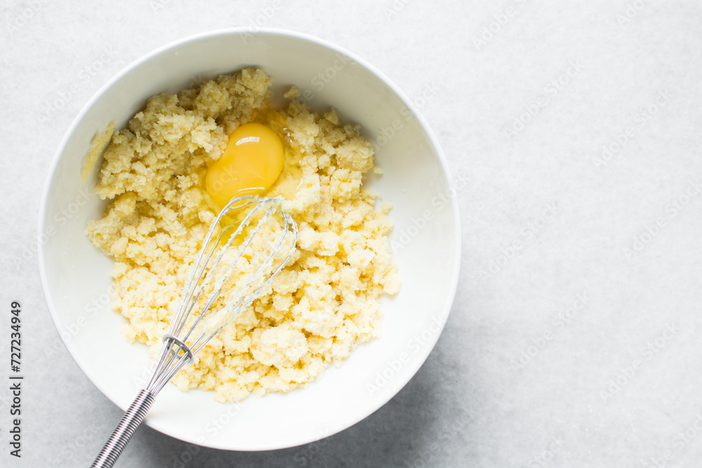Creaming butter, sugar and egg with a whisk, the process of making a cake, mixing butter, sugar and egg to make a cake