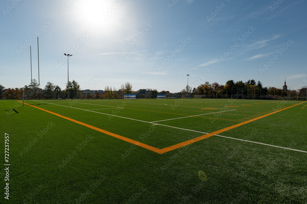Brand new football pitch with yellow lines at sunset