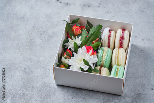 A box of classic French macaron in assorted. Gift box with flowers.