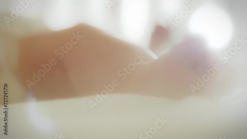 Close-up of the legs of newborn who is lying in his crib on a bright sunny day. The rays of the sun penetrate into the baby's crib, little feet show warmth and safety. Newborn kicks and moves his legs photo