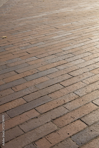 Square pavement paved with gray tiles rectangles texture. Vertical