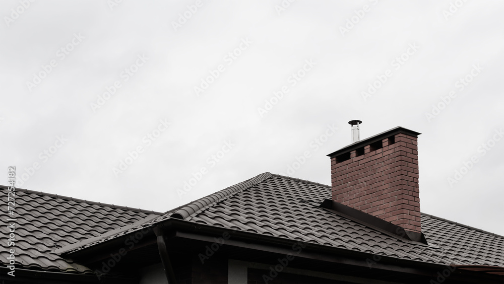 A fragment of a private new house with a fence and a roof A fragment of a private new house with a fence and a roof