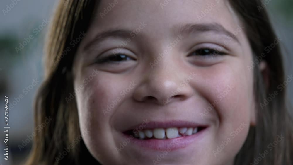 Macro close-up of joyful little girl smiling at camera, tight facial features of 8 year old child feeling happy Macro close-up of joyful little girl smiling at camera, tight facial features of 8 year old child feeling happy