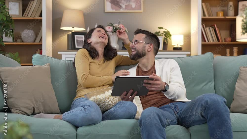 Couple caucasian man and woman sit at home on sofa bed watch movie Couple caucasian man and woman sit at home on sofa bed watch movie