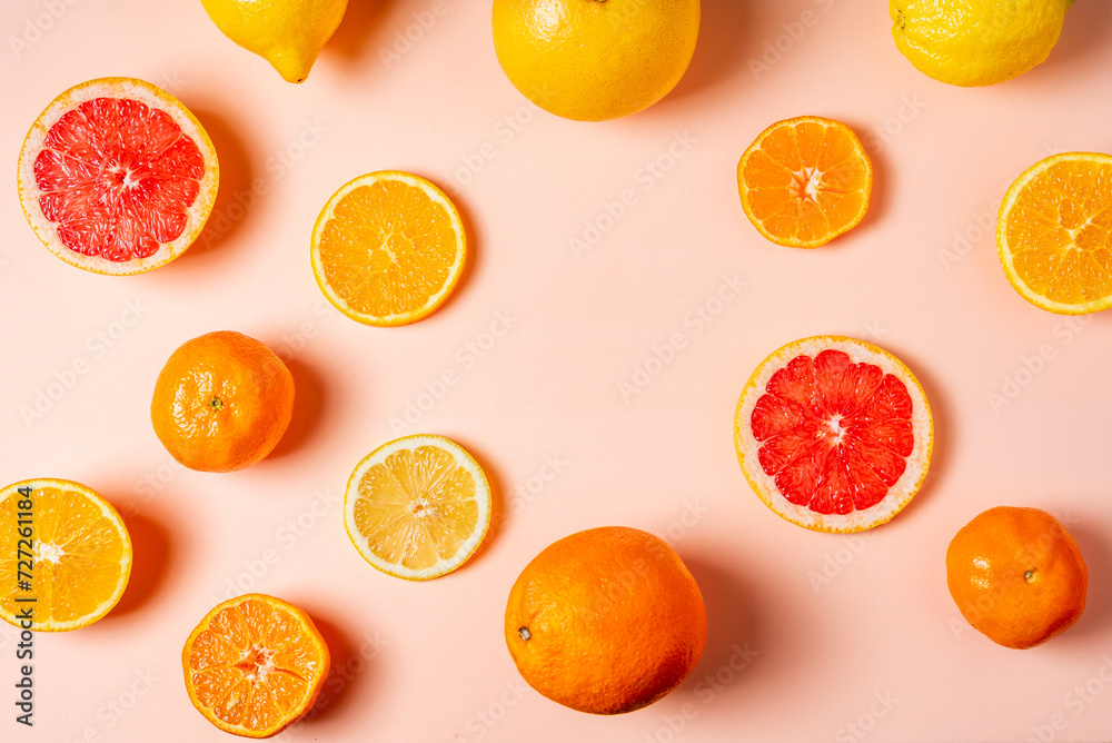 Collage of citrus fruits, whole, half and sliced, grapefruits, oranges, lemons and tangerines on a pink background, top view. Collage of citrus fruits, whole, half and sliced, grapefruits, oranges, lemons and tangerines on a pink background, top view.