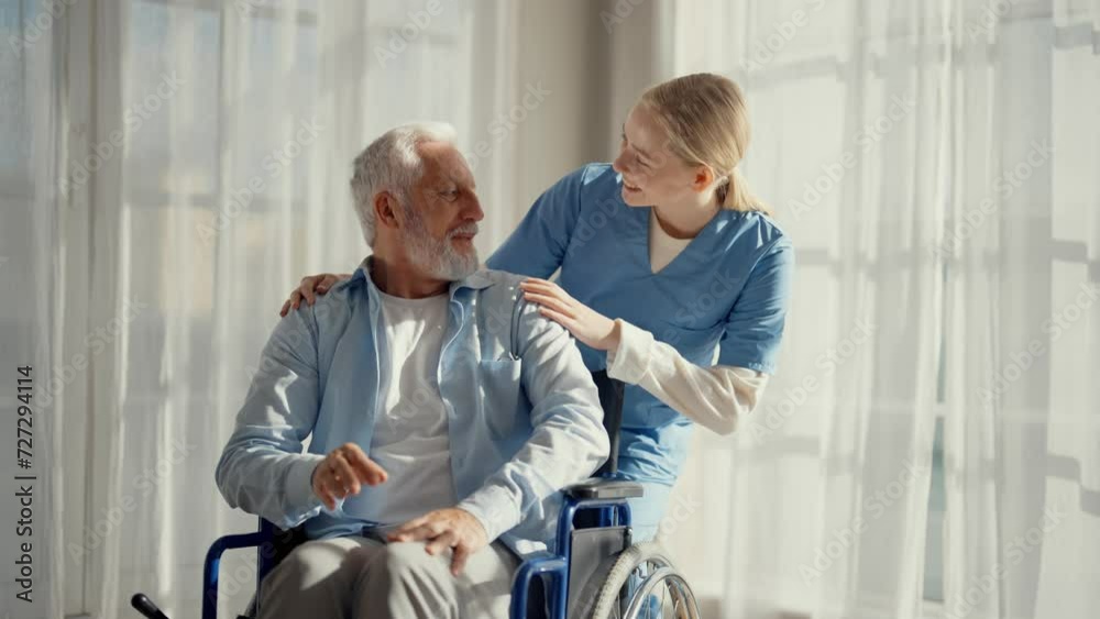 Social worker helps man in wheelchair. Woman nurse social welfare physical therapist looks after senior male, talking, providing medical care at hospital. Living with paralysis, special needs people. Social worker helps man in wheelchair. Woman nurse social welfare physical therapist looks after senior male, talking, providing medical care at hospital. Living with paralysis, special needs people.