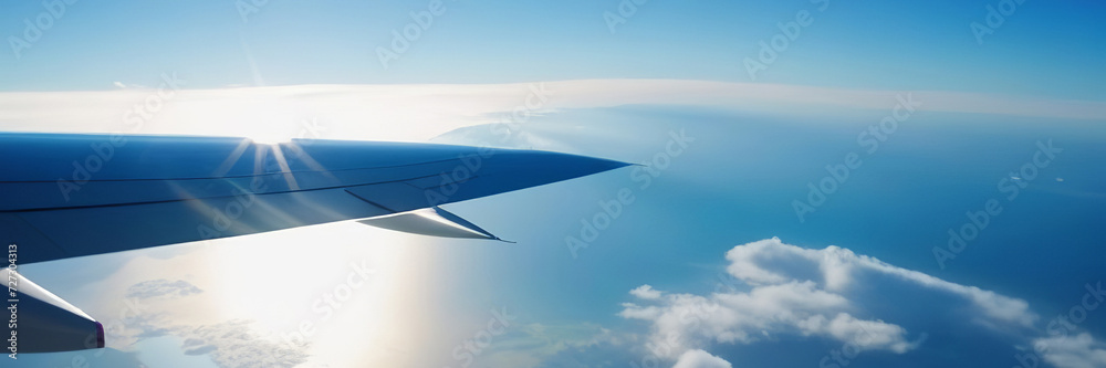 Flying above the sea of clouds. Features bright blue sky and white clouds. Slight curvature of the Earth at the horizon. Travel and vacation concept. Copy space banner Flying above the sea of clouds. Features bright blue sky and white clouds. Slight curvature of the Earth at the horizon. Travel and vacation concept. Copy space banner