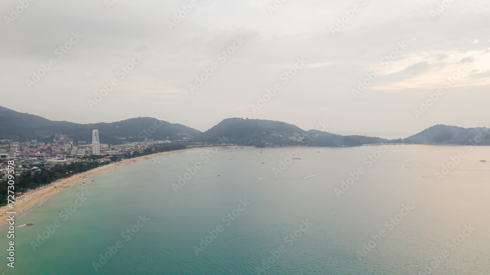 Aerial view, drone flying over Phuket city, Thailand. Drone over Patong Beach on Sunday in Phuket and tourists shopping at a street full of local merchants selling food, people resting by the sea.