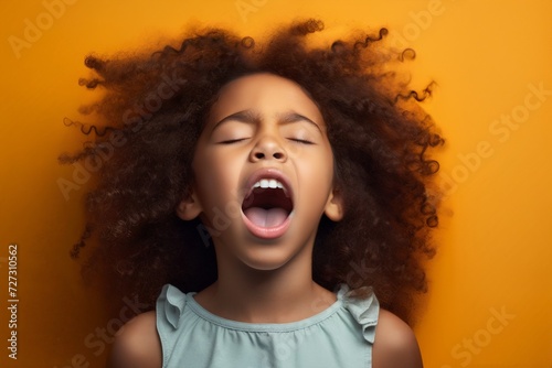 extremely whim Upset black curly haired young girl screaming and crying with opened mouth and closed eyes against color wall photo