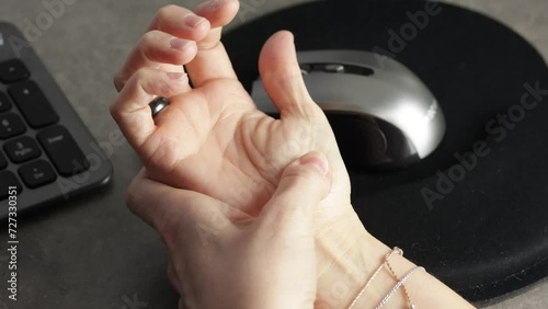 Gros plan d'une femme avec une douleur à la main due à l'utilisation d'un ordinateur. photo