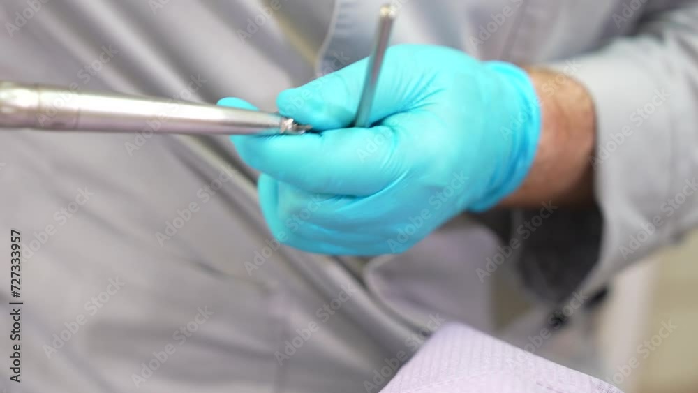 Close up of dentist holding a dental tool. Dentistry tool close up view. Dental equipment holding in hands.
Close up of dentist holding a dental tool. Dentistry tool close up view. Dental equipment holding in hands.