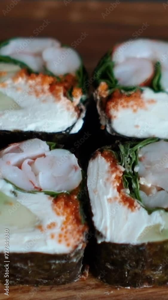 Japanese food with rice, red raw fish, cream cheese, salmon, shrimp, avocado and nori. Appetizing sushi set with rolls on the table. Incredibly tasty and expensive food from a sushi chef Japanese food with rice, red raw fish, cream cheese, salmon, shrimp, avocado and nori. Appetizing sushi set with rolls on the table. Incredibly tasty and expensive food from a sushi chef