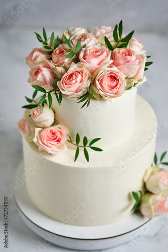 Delicate wedding bunk cake decorated with roses. White cake to order for a holiday.