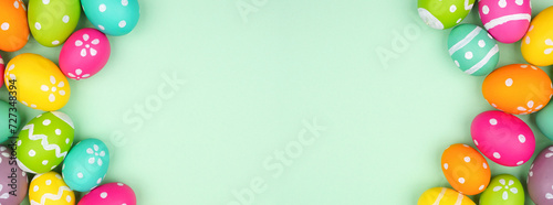 Colorful Easter Egg double border over a soft green paper banner background. Copy space.