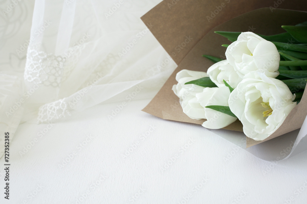 Fototapeta premium Bouquet of white tulips on a light background. Free space for text or inscription with greetings for Mother's Day, Spring Festival or Valentine's Day.