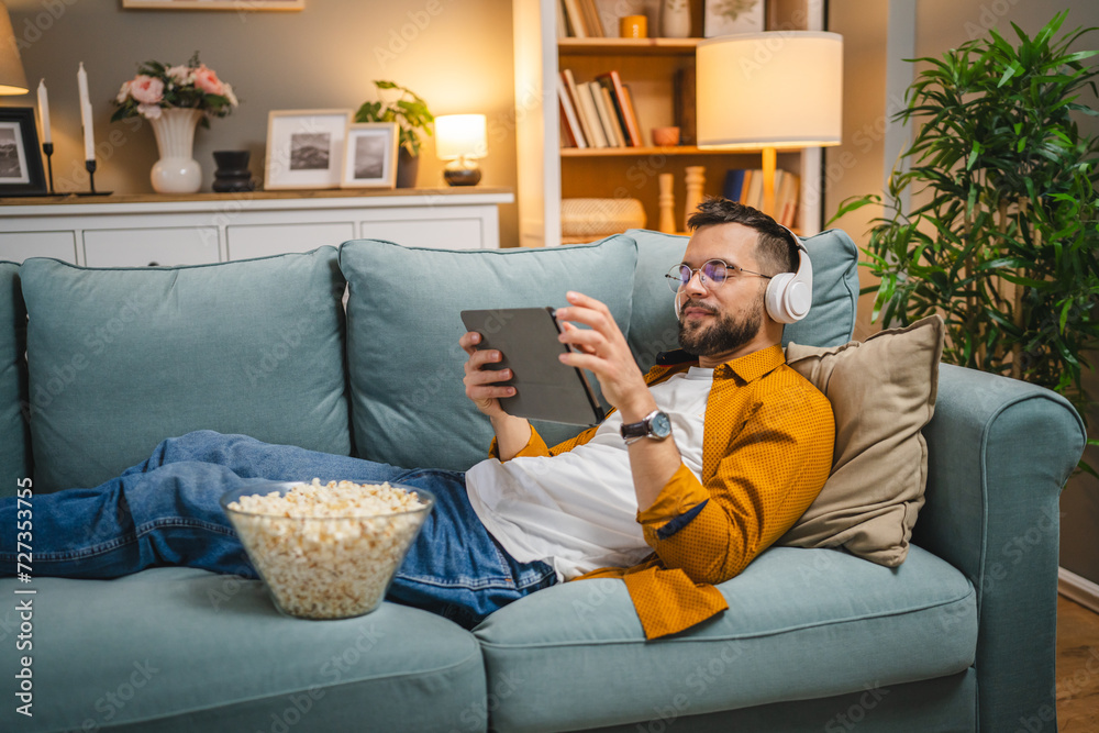 man sit on the sofa bed watch movie video online use digital tablet man sit on the sofa bed watch movie video online use digital tablet