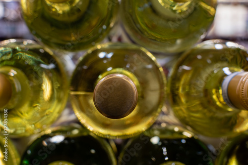 Stack of white wine bottles in horizontal position close-up © Irik