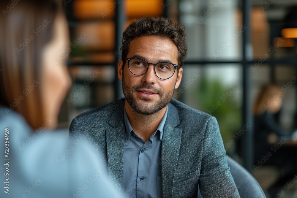 Professional man in discussion at modern office, engaging in conversation, blurred background. Professional man in discussion at modern office, engaging in conversation, blurred background.
