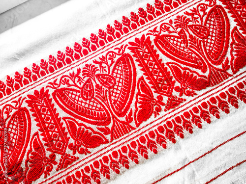 Gamosa or gamusa is a traditional textile pattern from Assam. It is a white piece of cloth with red stripes and red motifs, which is used in Bihu and resembles Ukrainian and Russian patterns. photo