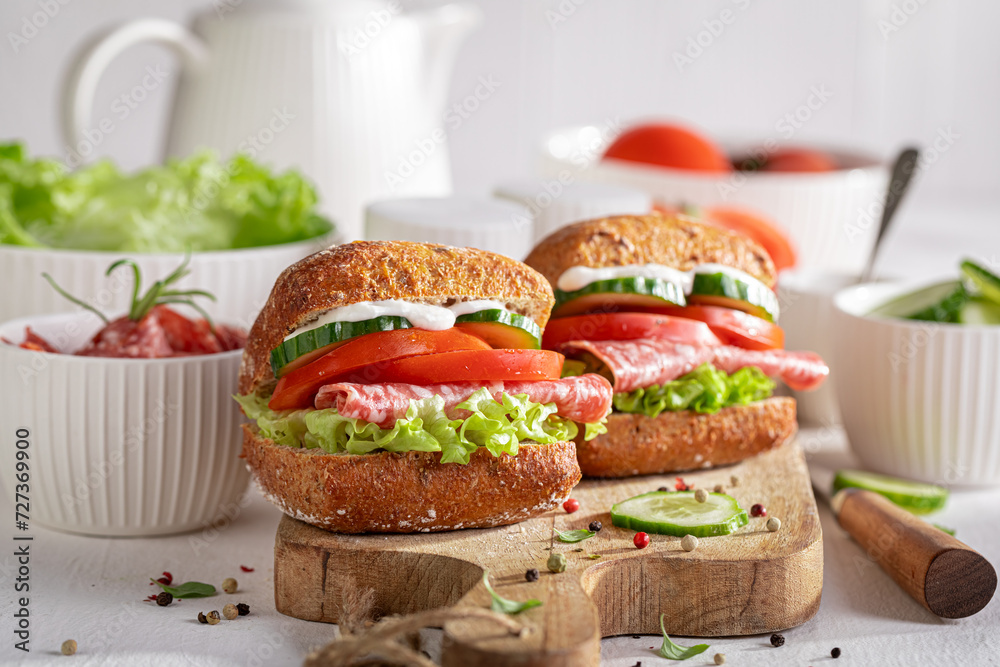 Tasty and spicy sandwich with salami, vegetables and mayonnaise. Tasty and spicy sandwich with salami, vegetables and mayonnaise.