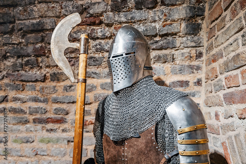 Medieval knight in full armor with weapon in fortress photo