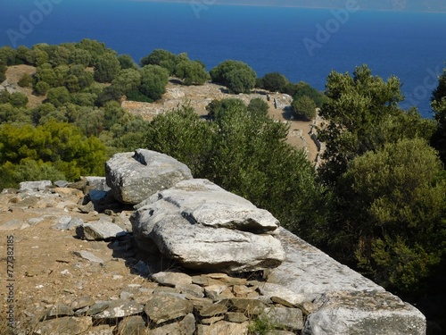 Ancient stones and a distant view of the ancient city of Rhamnous, in Attica, Greece photo