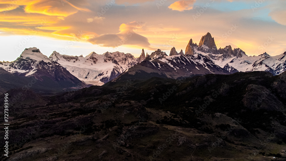 Obraz premium Sunset view from above of funicular clouds over Fitzroy El Chalten in Argentine Patagonia, majestic snow-capped mountains