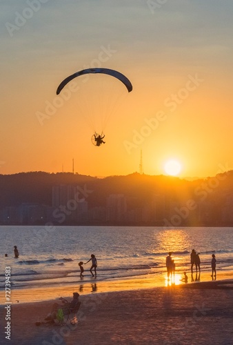 Paramotor flying over the beach sea during sunset. Santos city, Brazil. © Stefan Lambauer