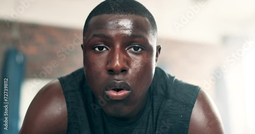 Gym, fitness and face of black man with workout, exercise and ready for challenge, boxing or training. Serious portrait of sports boxer breathing, sweating and tired for endurance or intense practice photo