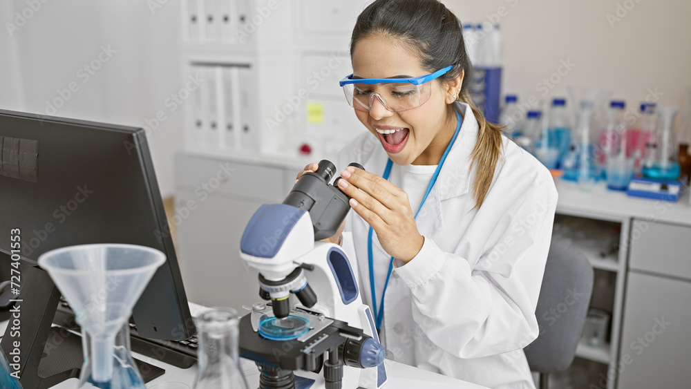 A surprised hispanic woman scientist examining a sample through a microscope in a laboratory setting. A surprised hispanic woman scientist examining a sample through a microscope in a laboratory setting.