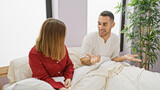 A couple conversing in bed, illustrating a casual, intimate moment within a modern bedroom interior.