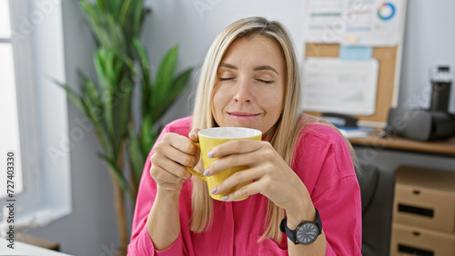 A young woman enjoys a coffee break at her office  radiating casual professionalism and relaxation.