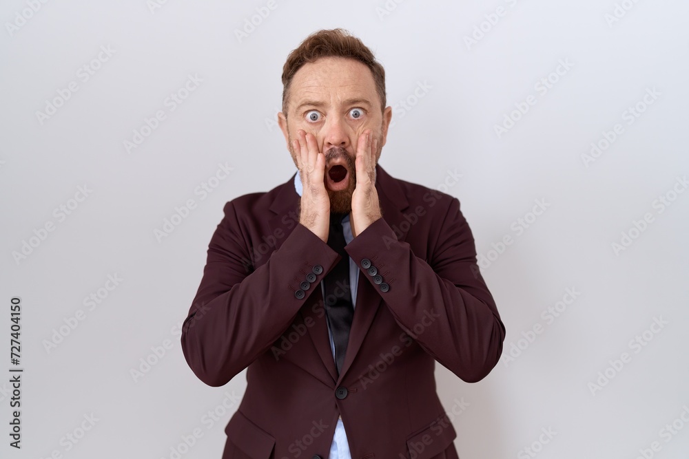 Middle age business man with beard wearing suit and tie afraid and shocked, surprise and amazed expression with hands on face Middle age business man with beard wearing suit and tie afraid and shocked, surprise and amazed expression with hands on face