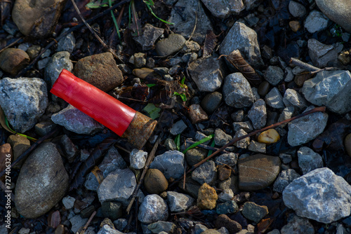 A spent cartridge case from a hunting cartridge lies in the middle of a mountain road.