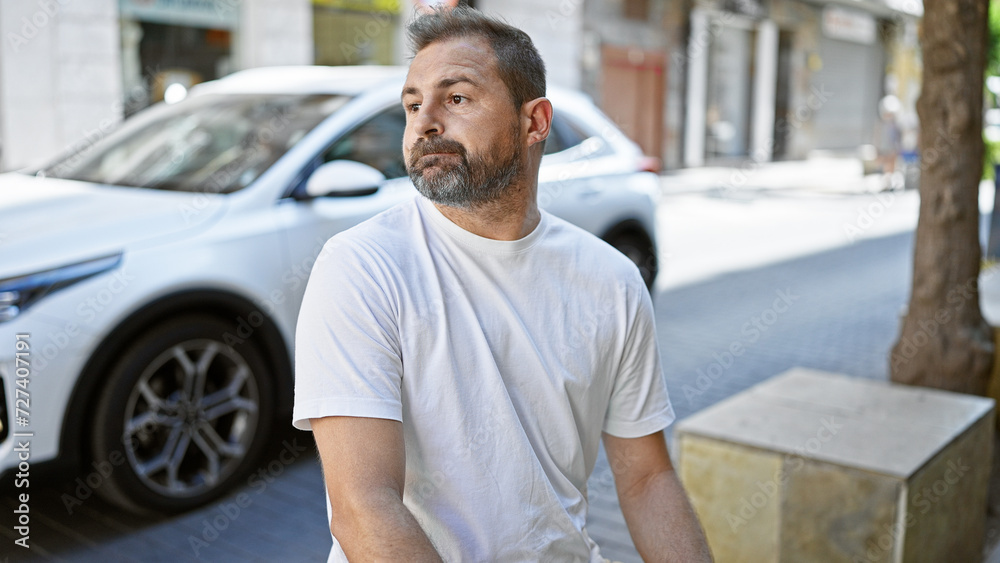 Handsome middle-aged hispanic man with grey hair standing on an urban street, evoking a sense of city life and calmness. Handsome middle-aged hispanic man with grey hair standing on an urban street, evoking a sense of city life and calmness.