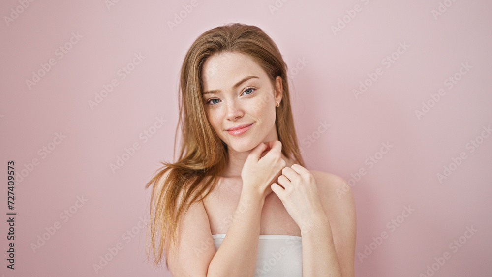 Young blonde woman smiling confident touching face with hands over isolated pink background Young blonde woman smiling confident touching face with hands over isolated pink background