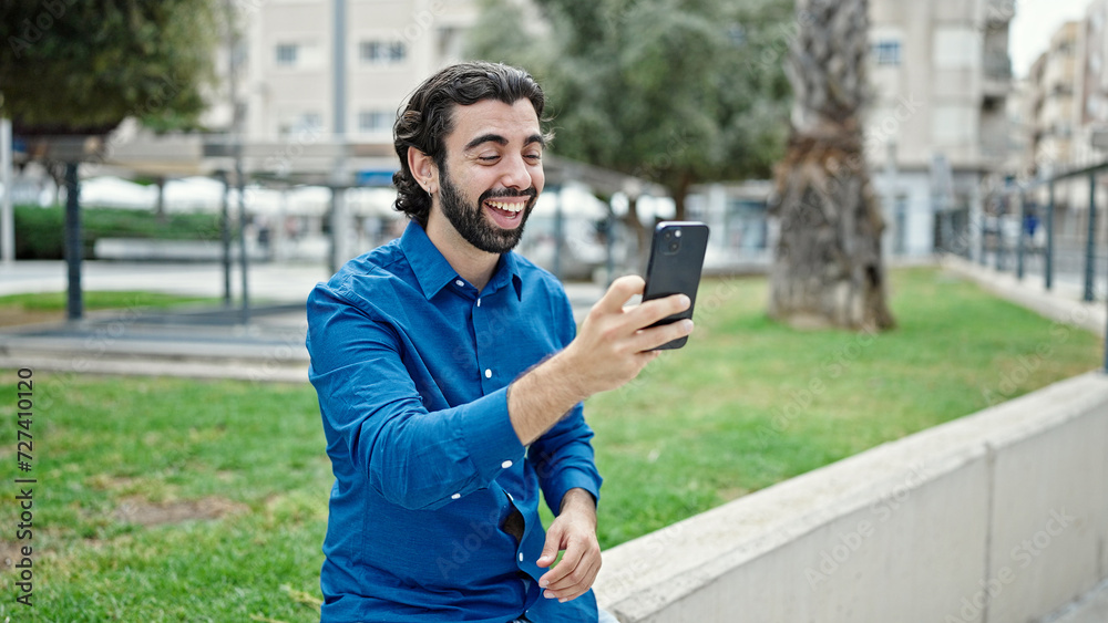 Young hispanic man smiling confident having video call at park