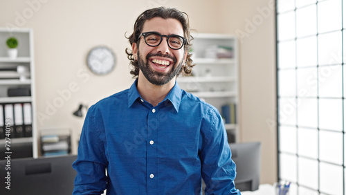 Young hispanic man business worker laughing a lot at the office photo