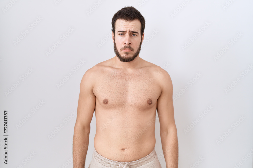 Fototapeta premium Young hispanic man standing shirtless over white background depressed and worry for distress, crying angry and afraid. sad expression.