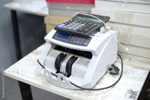Old dusty money counter machine and calculator in the office. Cash counter, banknote counter and calculating machine for an article about finance, business, money, financial crisis, inflation.