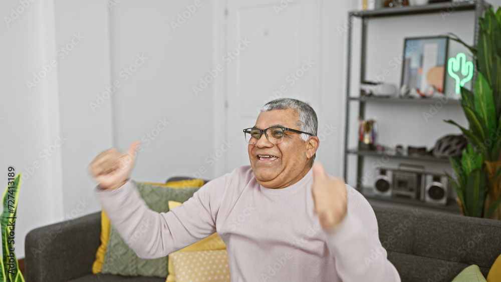 Fototapeta premium A cheerful middle-aged man celebrates in a cozy living room with modern decor.