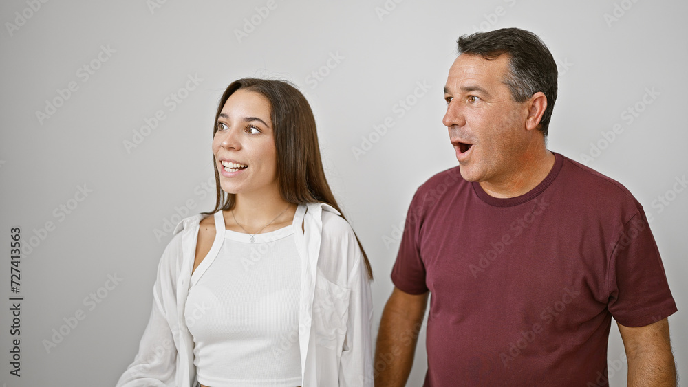 Father-daughter duo amazed, cute hispanic family looking to side with surprise, smiling confidently on white isolated background Father-daughter duo amazed, cute hispanic family looking to side with surprise, smiling confidently on white isolated background