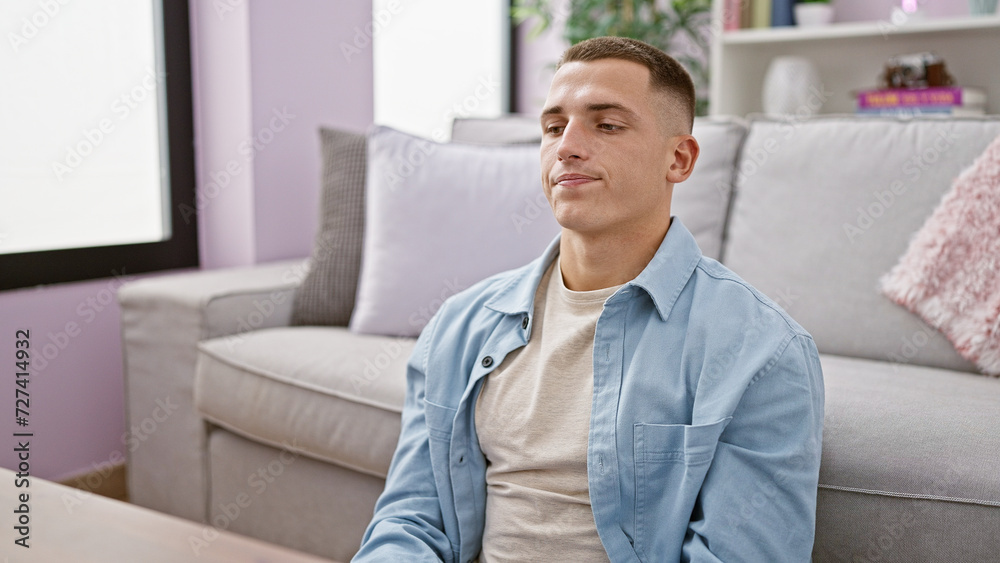 Handsome hispanic man relaxing in a modern living room apartment