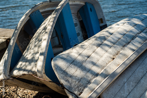 Old boats on the lake bank in the summer day photo