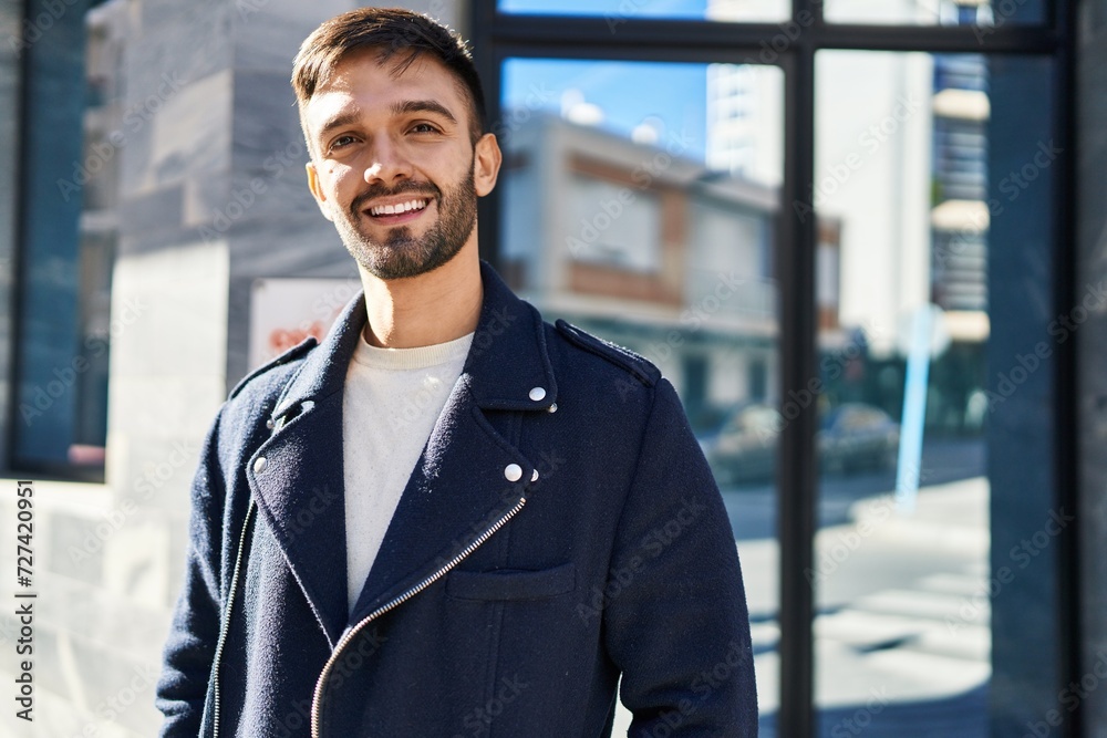 Obraz premium Young hispanic man smiling confident standing at street