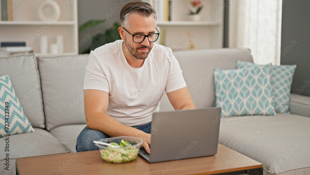 Grey-haired man using laptop at home