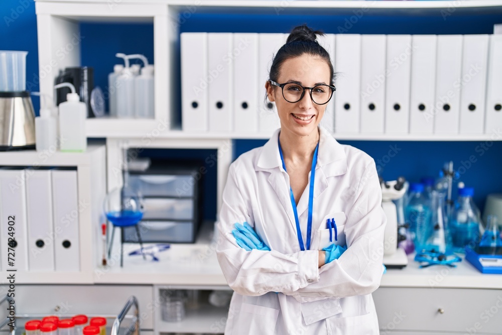 Young caucasian woman scientist smiling confident standing with arms crossed gesture at laboratory